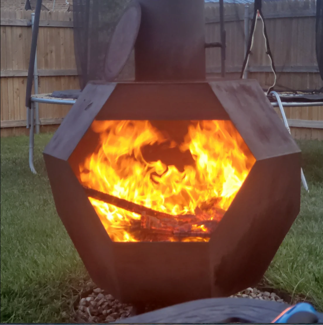 Actual custom six-foot steel chimney fire pit burning outdoors