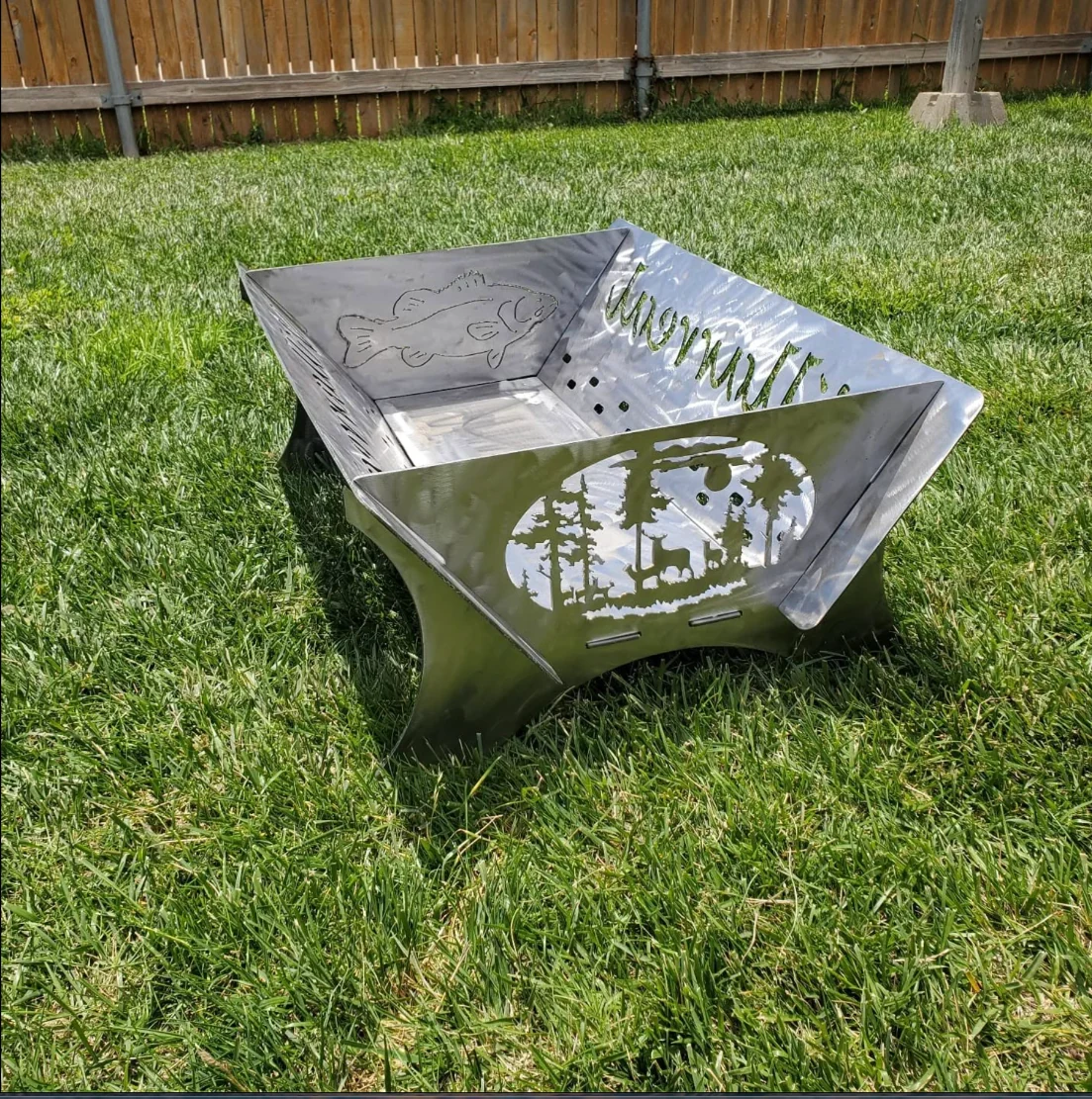 Actual custom metal fire pit with plasma-cut outdoor scenes and family lettering